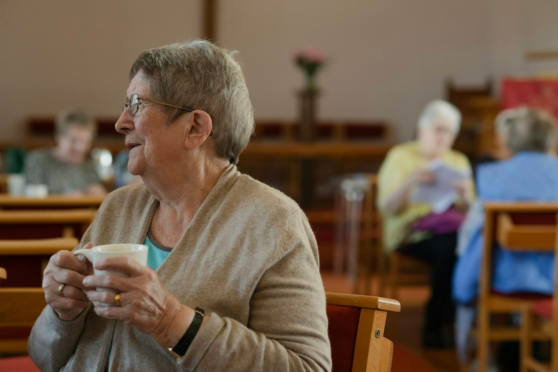 Older women chatting over coffee in a bright community room